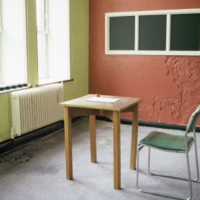Writing desk, chair and vandalised wall